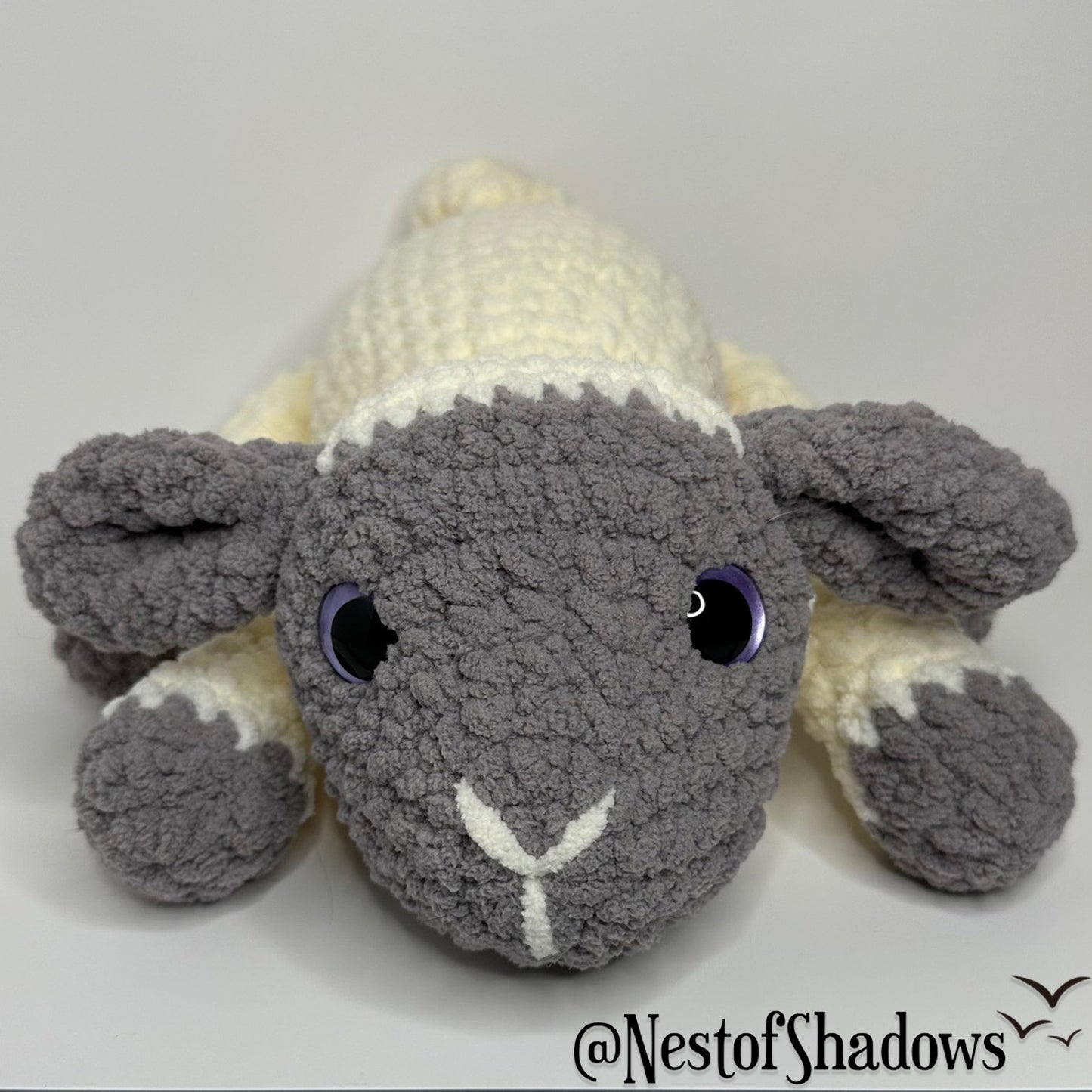 Gray and white crochet lab plushie with a white background and Nest of Shadows watermark.