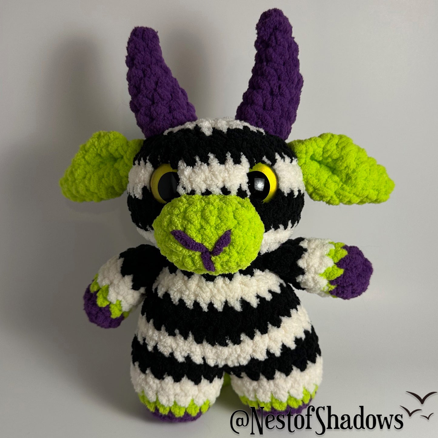 Crochet goat with stripes and white background. Nest of Shadows watermark.