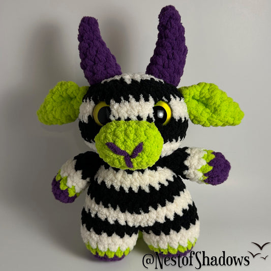 Crochet goat with stripes and white background. Nest of Shadows watermark.