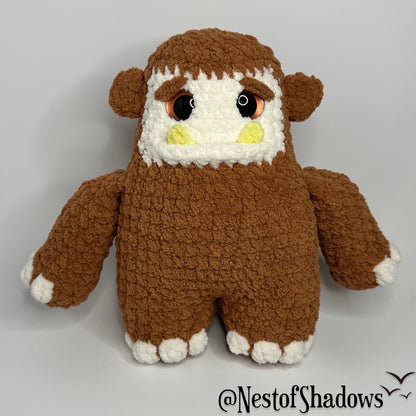 Bigfoot crochet plushie with a while background and Nest of Shadows watermark.