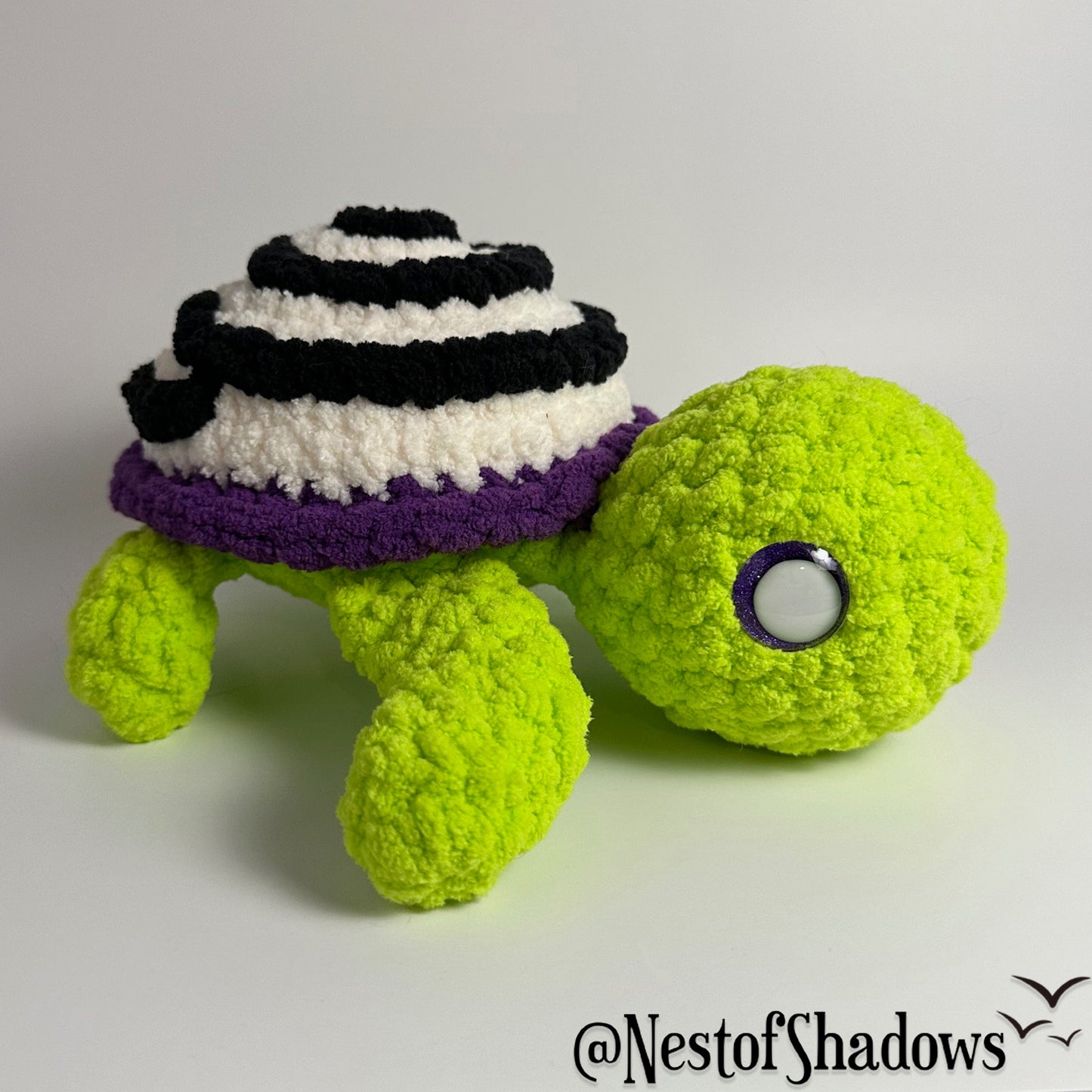 Crochet turtle on a white background. Nest of Shadows watermark.