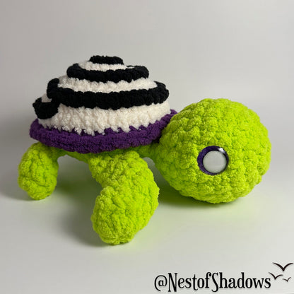 Crochet turtle on a white background. Nest of Shadows watermark.