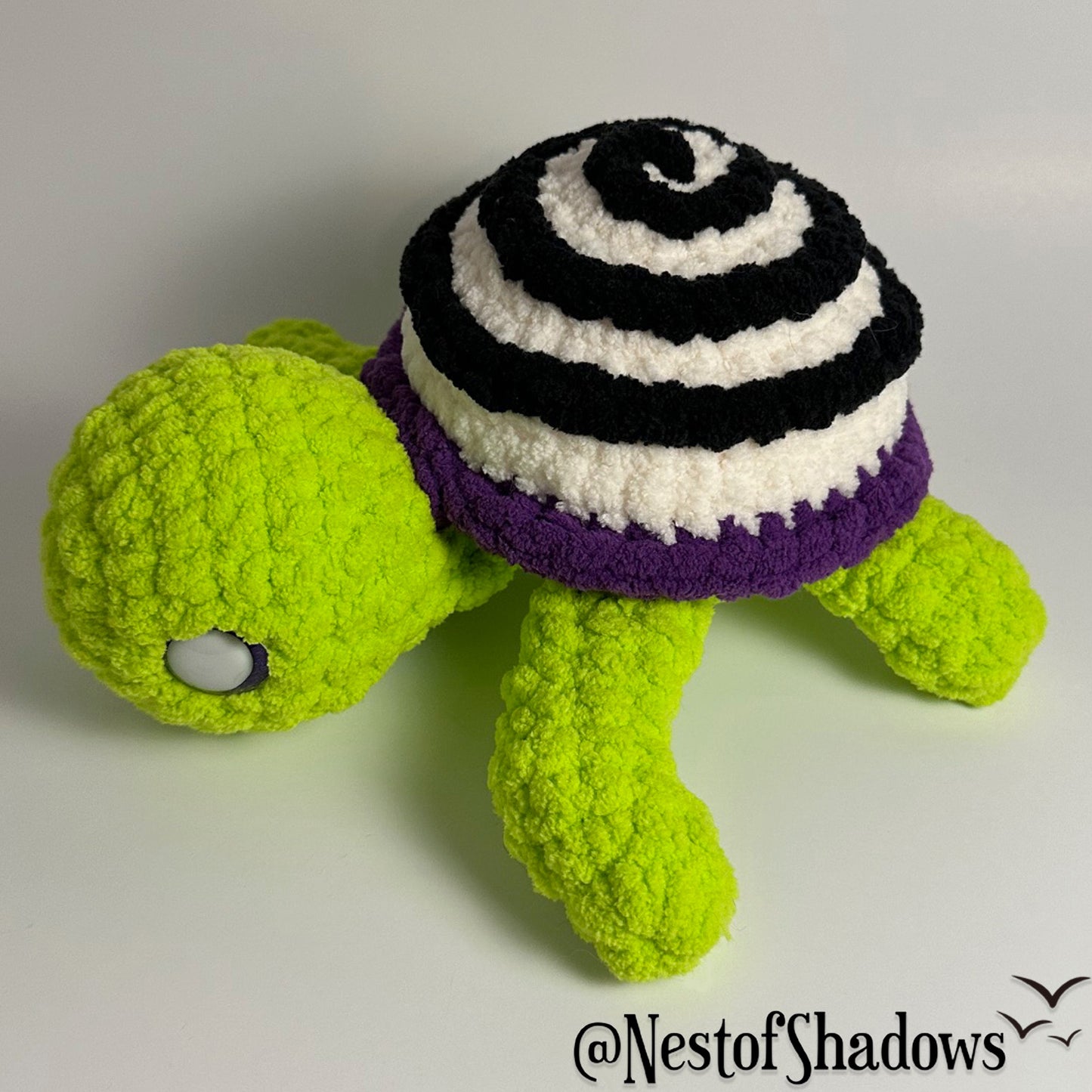 Crochet turtle on a white background. Nest of Shadows watermark.