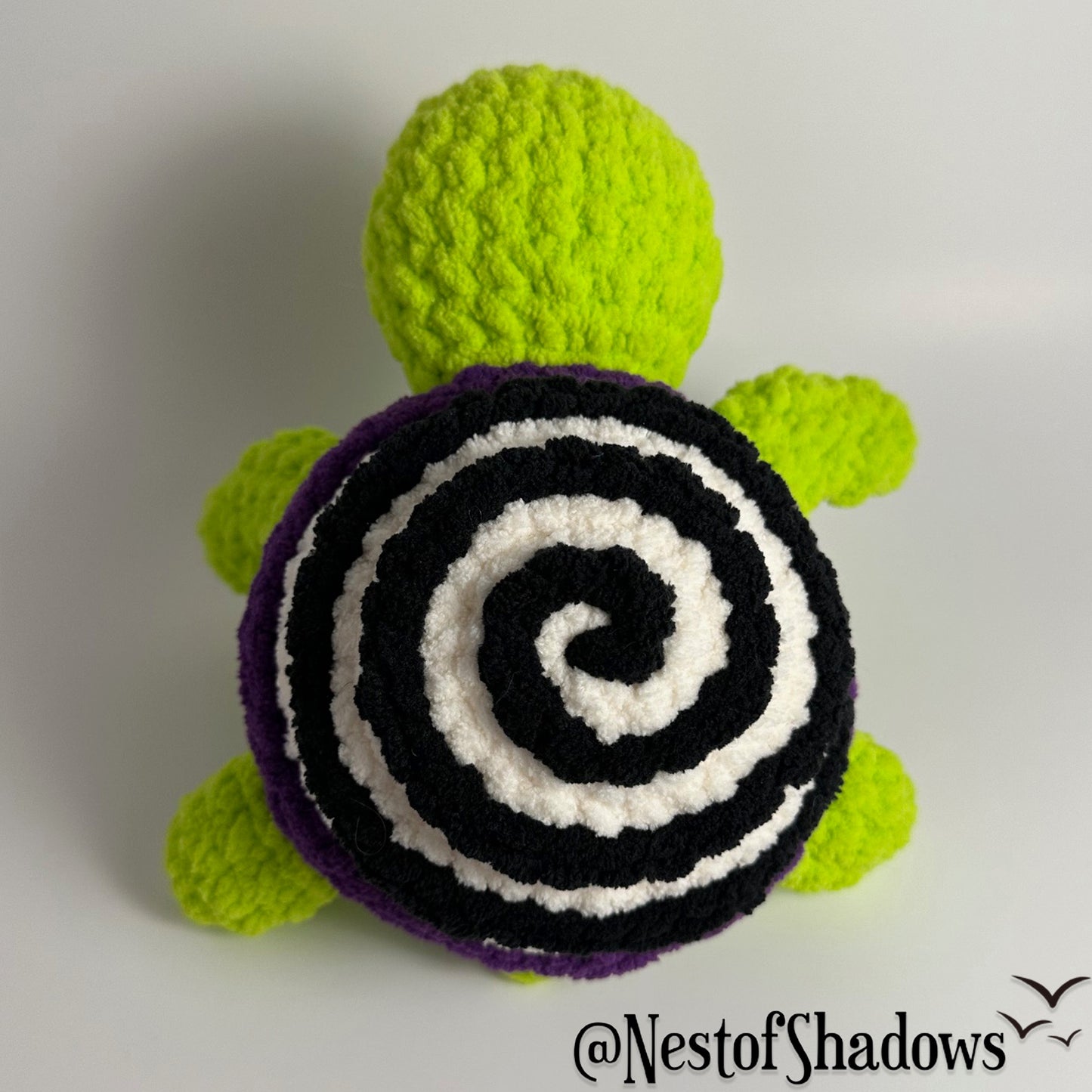 Crochet turtle on a white background. Nest of Shadows watermark.