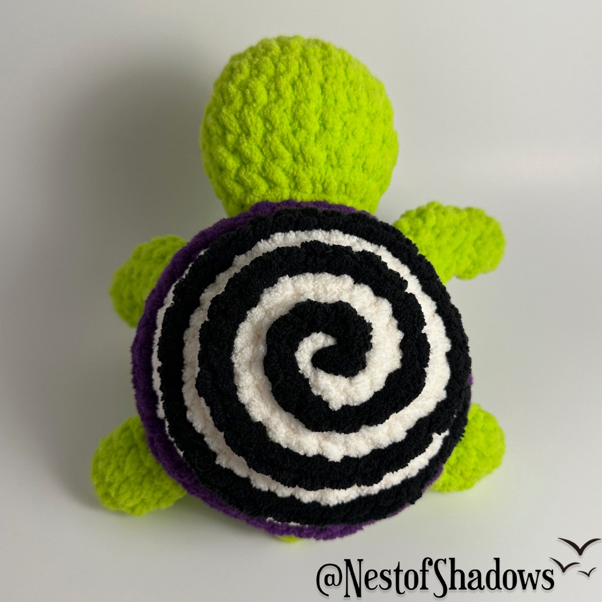 Crochet turtle on a white background. Nest of Shadows watermark.