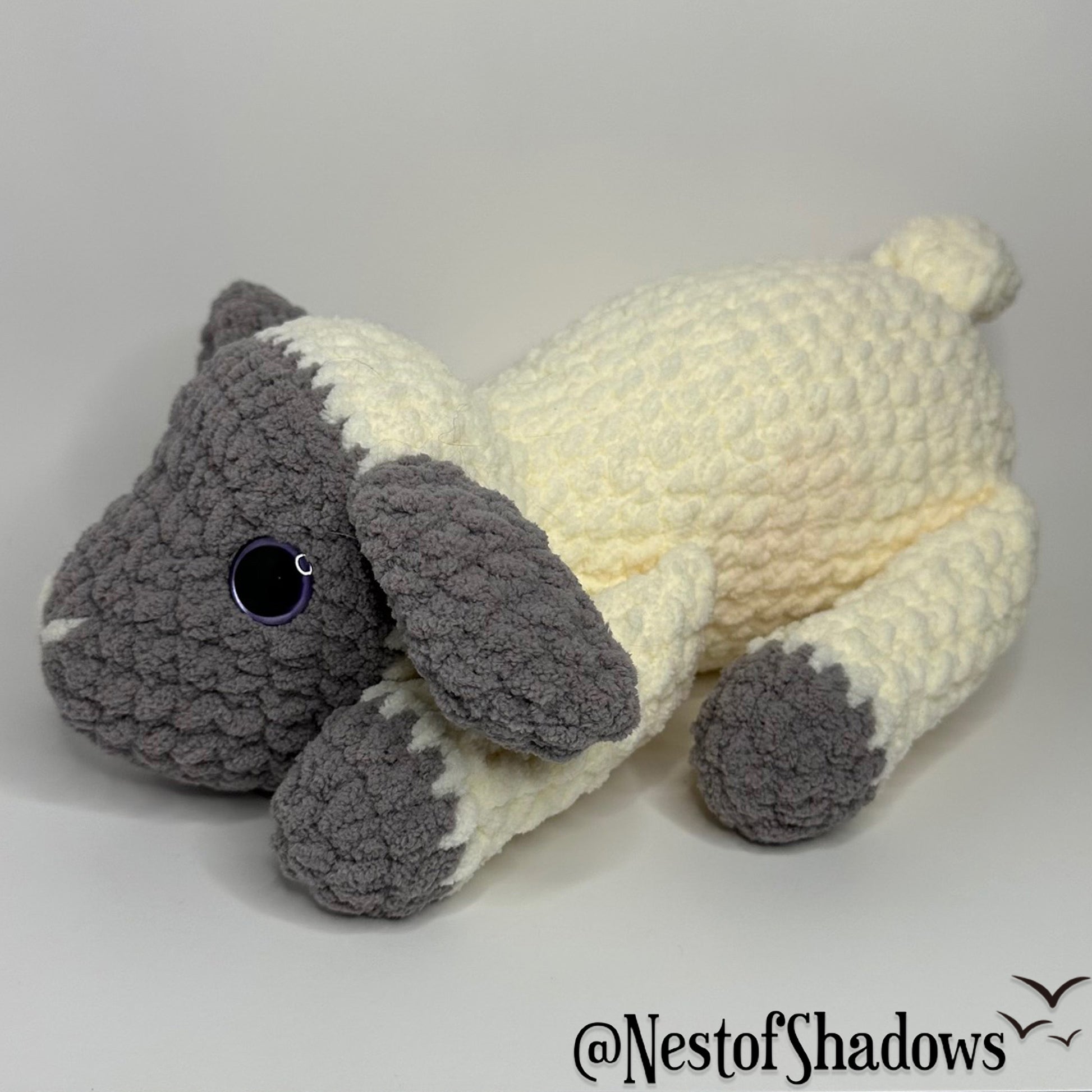 Gray and white crochet lab plushie with a white background and Nest of Shadows watermark.
