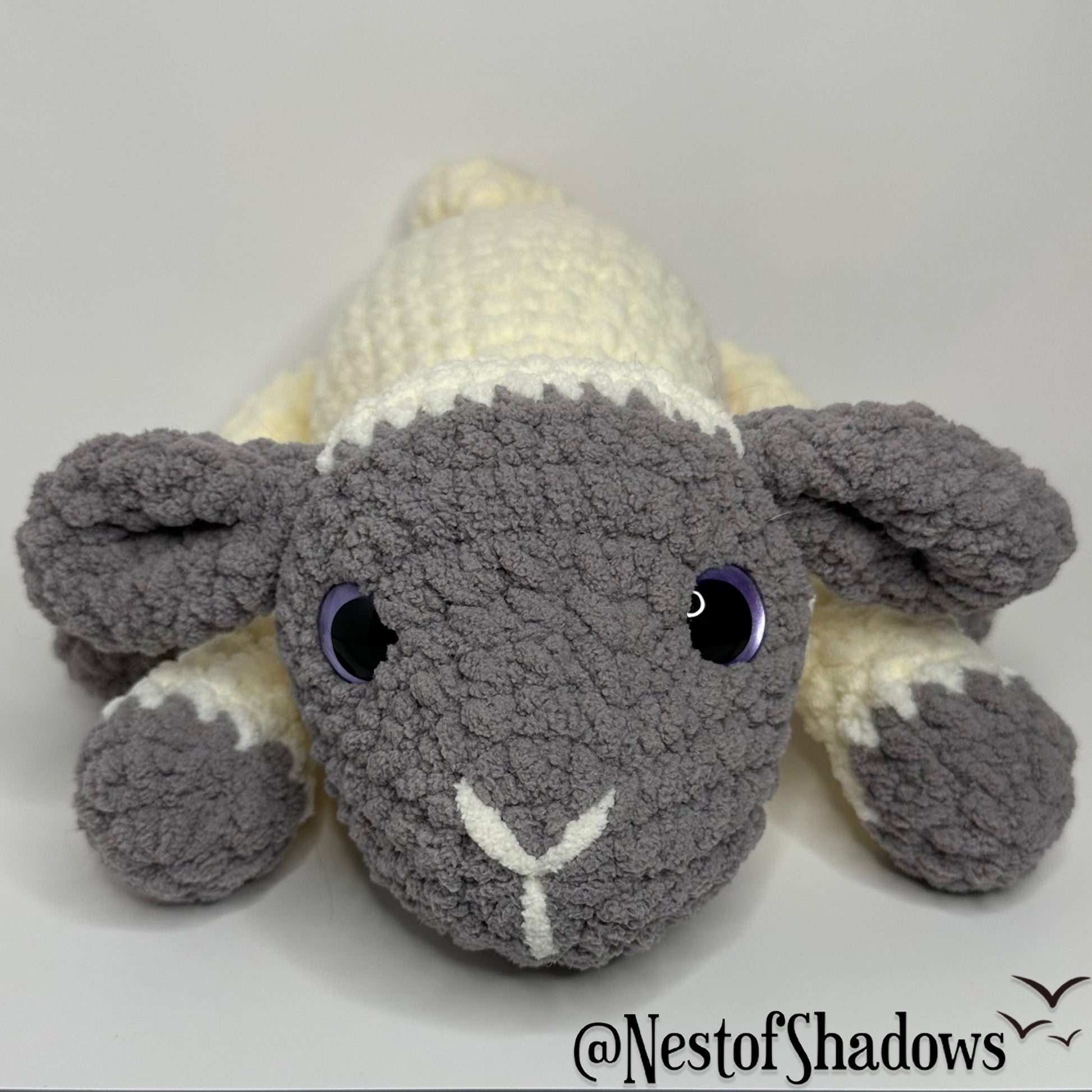 Gray and white crochet lab plushie with a white background and Nest of Shadows watermark.